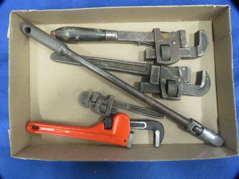Four pipe wrenches and a breaker bar AAA Auction and Realty