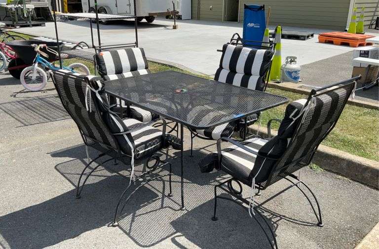 Metal patio table with 4 chairs with black and white cushions , table