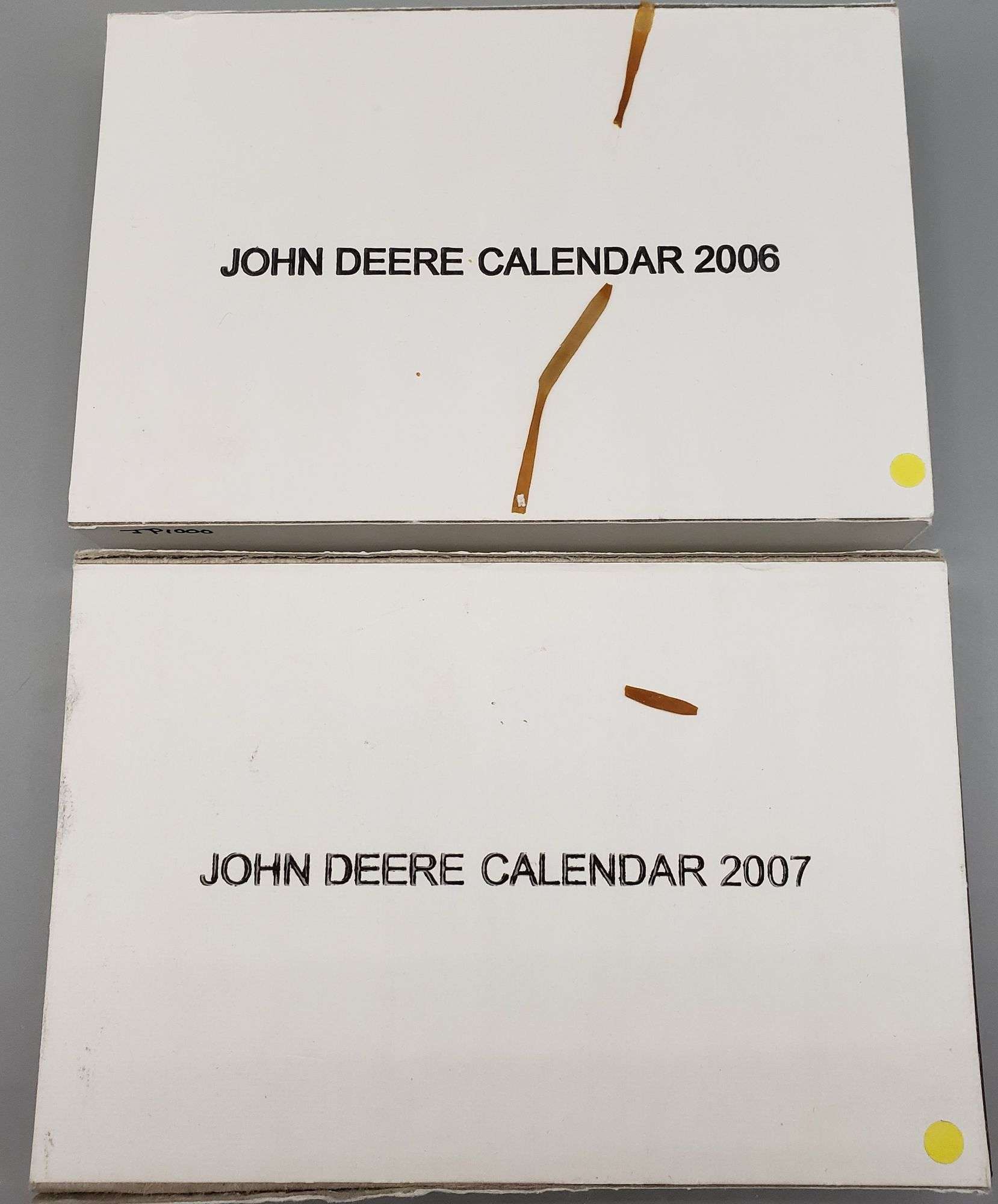 2) John Deere Brass Calendar Medals, stands, certificates and boxes. 2006  and 2007 - Adam Marshall Land & Auction, LLC