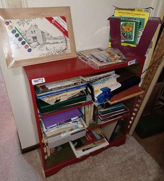 Red and green painted bookshelf with art supplies, books, Etc Mark
