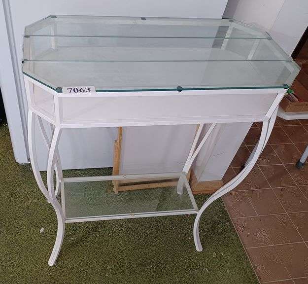 White metal stand with three piece glass top, glass shelf on base