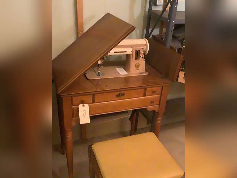 Singer sewing machine with knee and foot pedal. Sewing book and