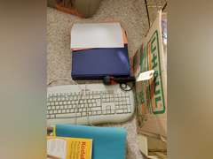 Box full of miscellaneous office supplies and accessories,  keyboard, binders, hanging folders