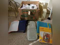 Box full of miscellaneous office supplies and accessories,  keyboard, binders, hanging folders